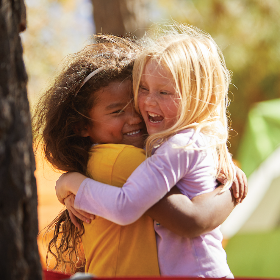 black and white girl hugging at camp